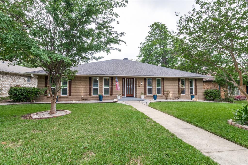 9552 Timberleaf Drive Dallas, TX 75243 - Photo 2 of 32 a front view of a house with a garden and trees