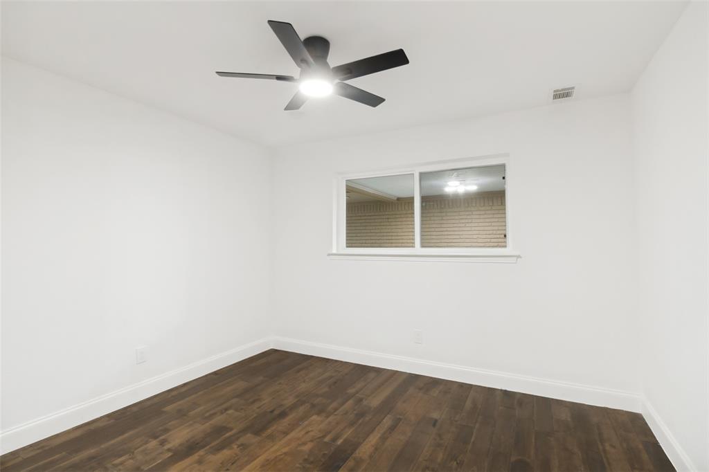 9552 Timberleaf Drive Dallas, TX 75243 - Photo 23 of 32 an empty room with wooden floor and windows