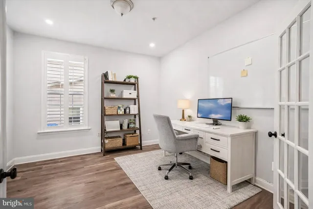 an empty room with windows fireplace and wooden floor