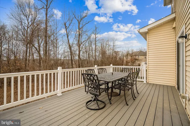a view of an empty room with wooden floor and a ceiling fan