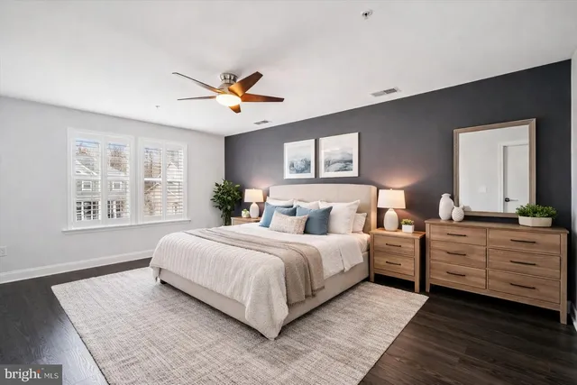 an empty room with wooden floor and a ceiling fan
