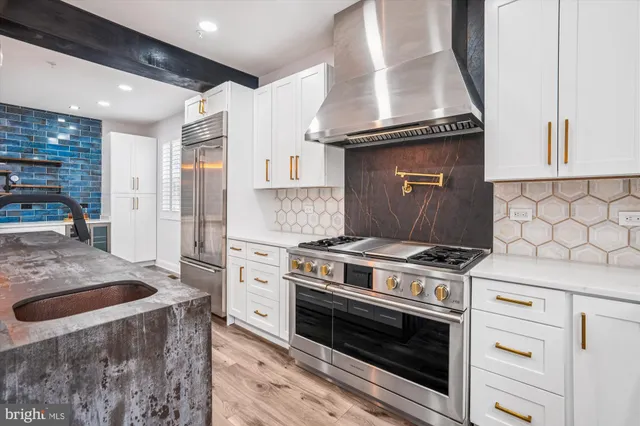 a kitchen with granite countertop a table chairs stove a sink and dishwasher