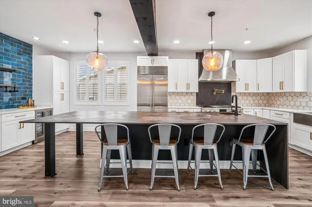 a kitchen with stainless steel appliances granite countertop a kitchen island a stove and a wooden floors