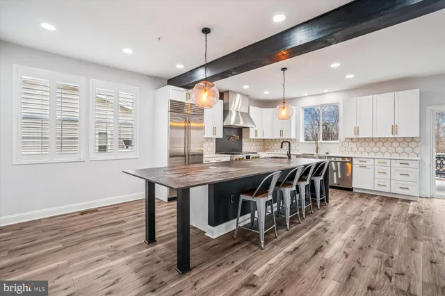 a kitchen with stainless steel appliances granite countertop a sink window and cabinets