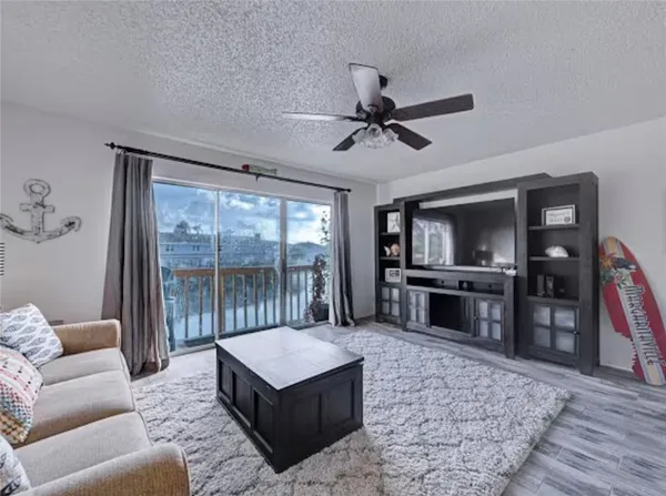 a living room with furniture a flat screen tv and a floor to ceiling window