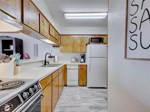 a kitchen with sink a refrigerator and a stove