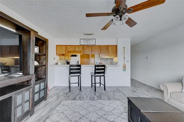 a view of a kitchen with kitchen island a counter space a sink appliances and cabinets
