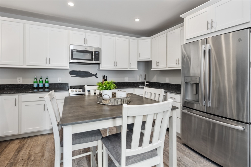 16 R Gannett Road Scituate, MA 02066 - Photo 2 of 22 a kitchen with stainless steel appliances granite countertop a refrigerator a sink a stove a table and chairs