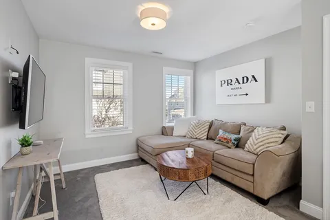a living room with furniture a flat screen tv and a large window
