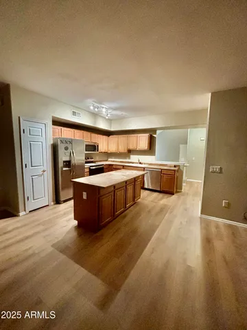 a large kitchen with stainless steel appliances a large counter top and a stove