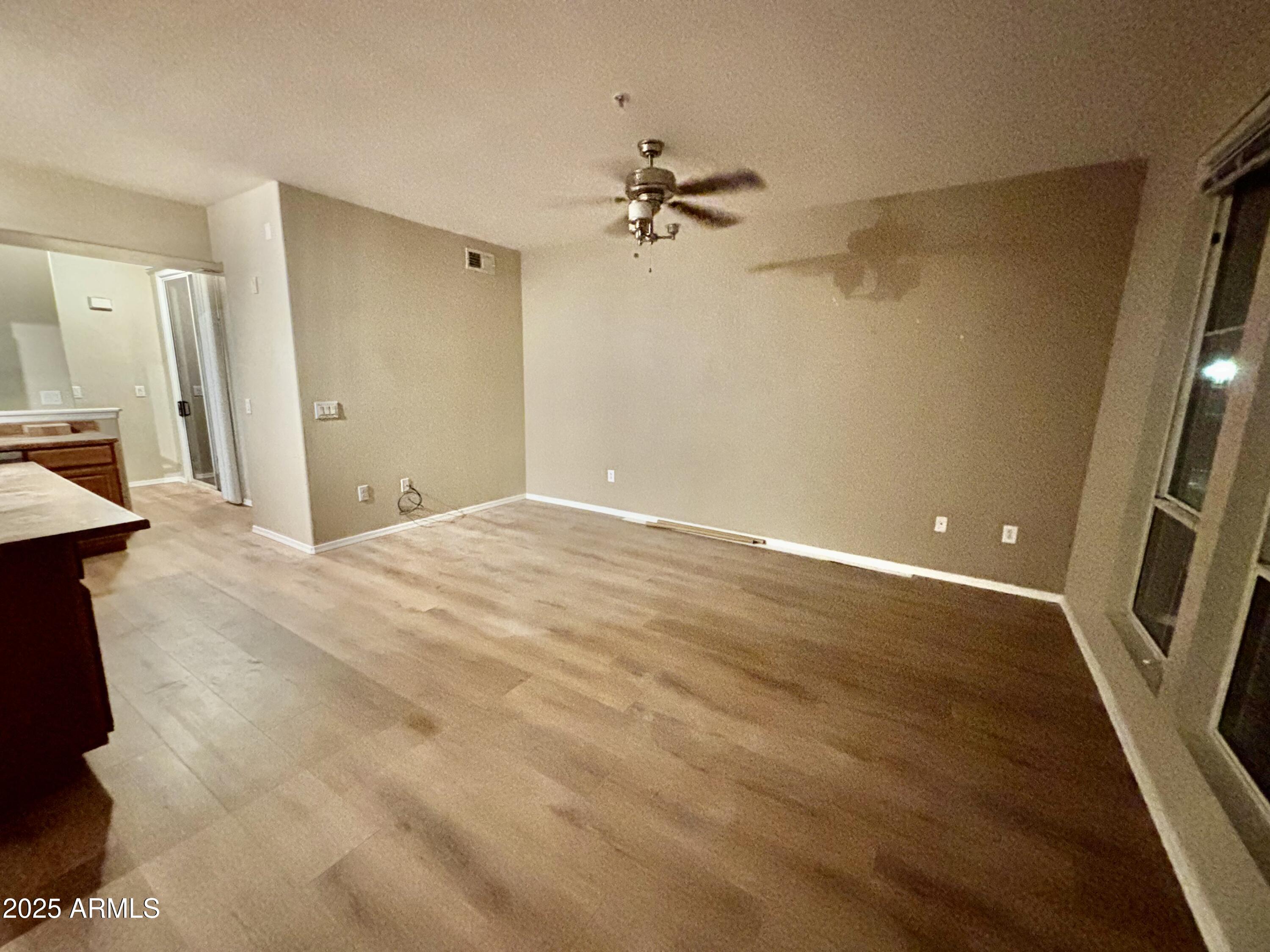 18250 North Cave Creek Road, Unit 129 Phoenix, AZ 85032 - Photo 5 of 14 wooden floor in an empty room with a window