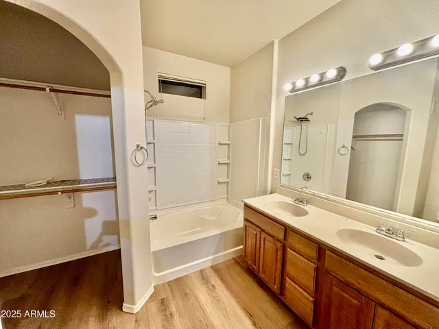 a bathroom with a tub sink shower and a mirror