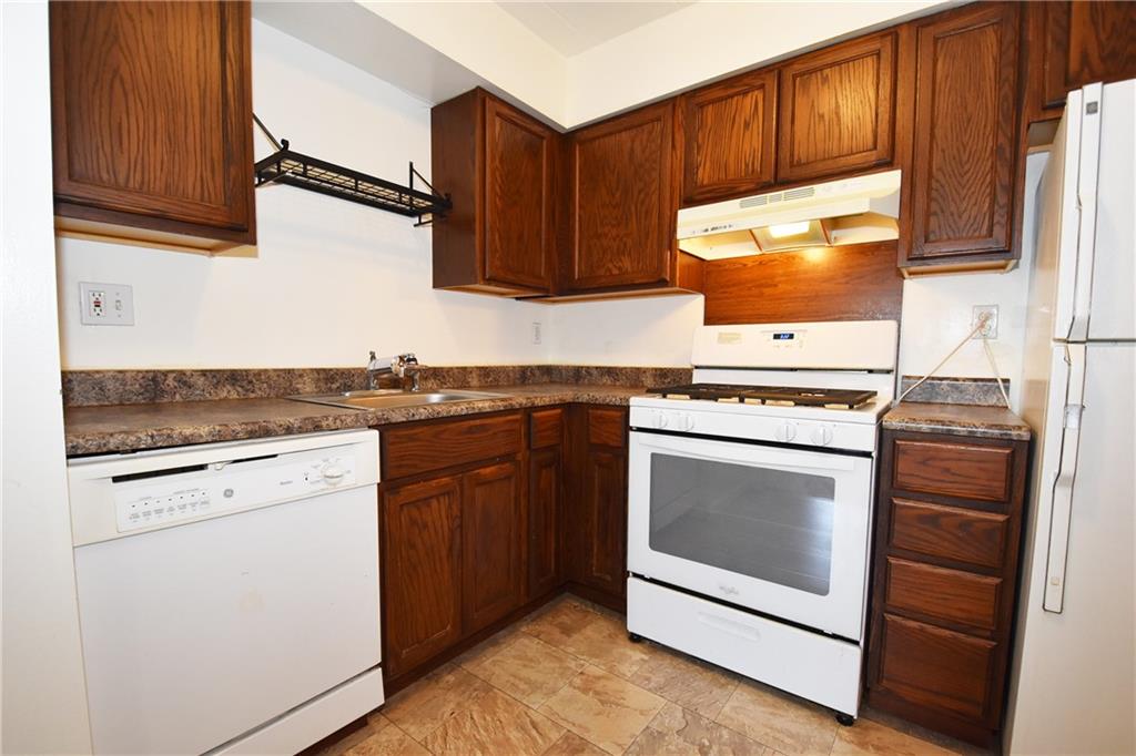 5 Bayard Road, Unit 210 Pittsburgh, PA 15213 - Photo 10 of 22 a kitchen with granite countertop wooden cabinets stainless steel appliances and a sink