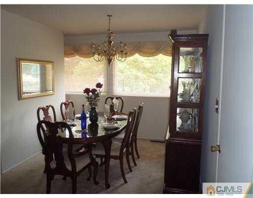 21 Rumson Road Kendall Park, NJ 08824 - Photo 3 of 16 a view of a dining room with furniture a chandelier and window