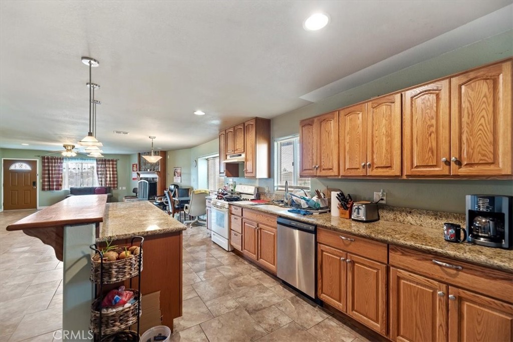 13285 Mesquite Road Apple Valley, CA 92308 - Photo 9 of 33 a large kitchen with lots of counter space a sink a window and stainless steel appliances