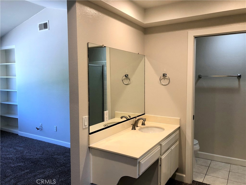 16 Prescott Irvine, CA 92620 - Photo 14 of 23 a bathroom with a sink a mirror and a shower