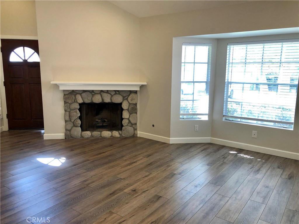 16 Prescott Irvine, CA 92620 - Photo 4 of 23 an empty room with wooden floor fireplace and windows
