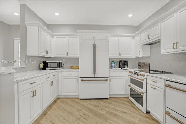 a kitchen with white cabinets and sink