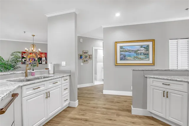 a kitchen with granite countertop white cabinets and white appliances