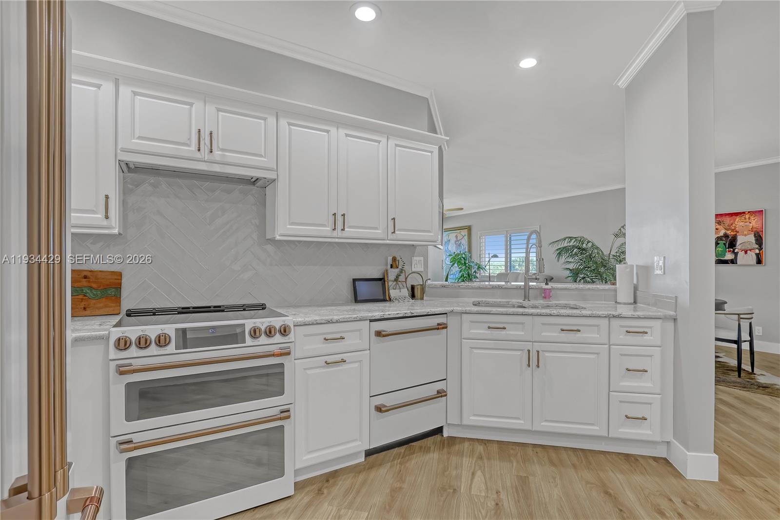 6062 Southeast Landing Way, Unit 16 Stuart, FL 34997 - Photo 17 of 35 a kitchen with granite countertop white cabinets and white appliances