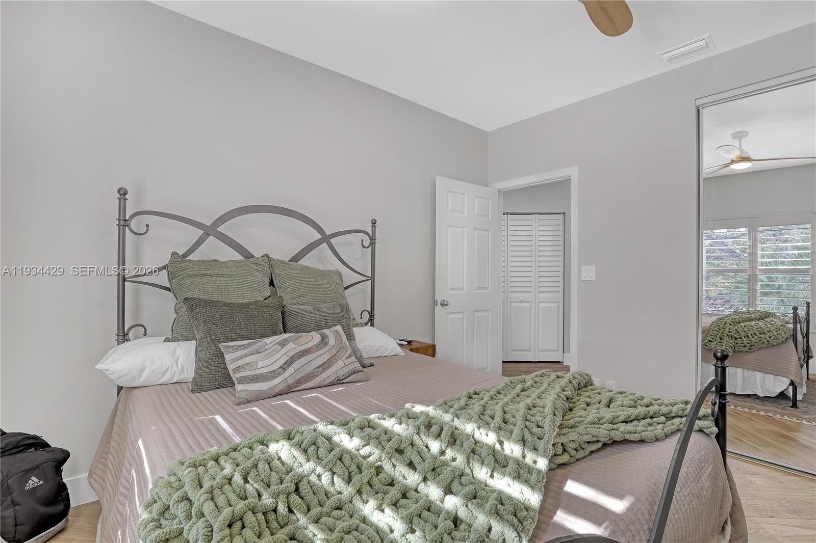 6062 Southeast Landing Way, Unit 16 Stuart, FL 34997 - Photo 26 of 35 a bedroom with a bed a mirror and chair
