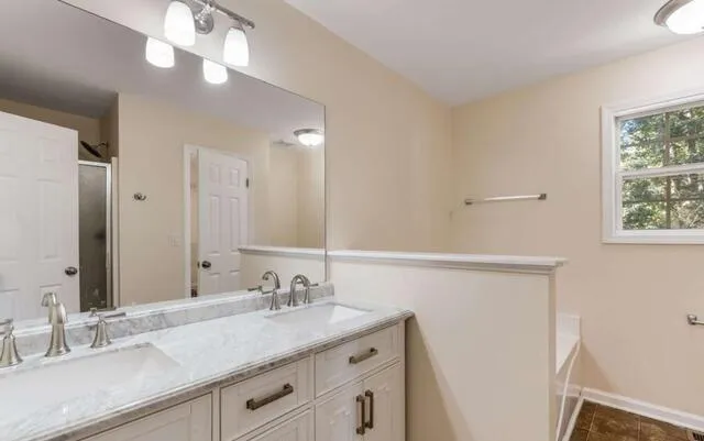 a bathroom with a granite countertop sink and a mirror