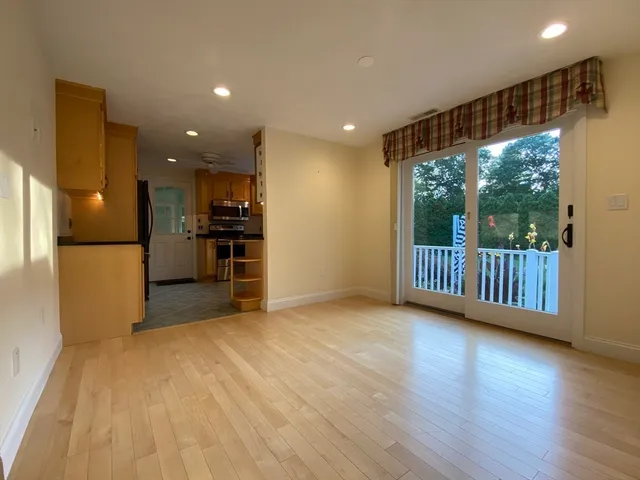 a view of a electric appliances in kitchen and empty room with wooden floor
