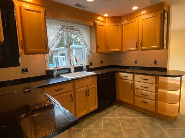 a kitchen with stainless steel appliances granite countertop a sink a stove and a granite counter tops with a large window