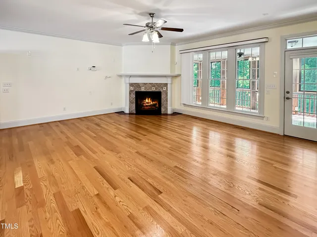 a view of empty room with wooden floor and fireplace