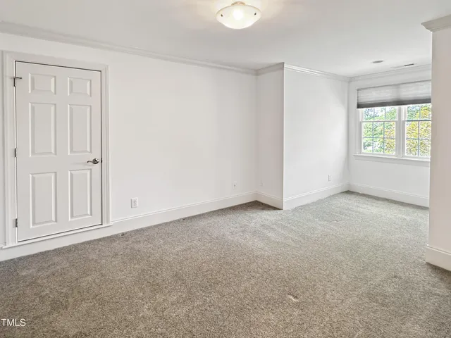an empty room with windows and ceiling fan