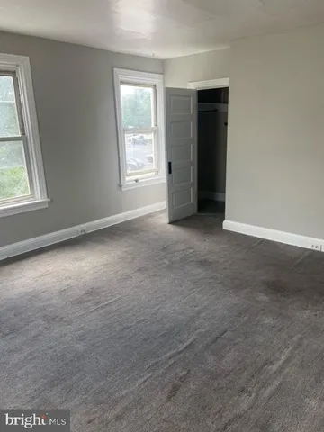 an empty room with windows and closet