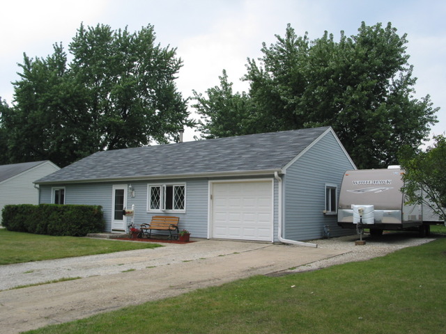 64 Eastfield Road Montgomery, IL 60538 - Photo 1 of 22 a front view of a house with a garden and tree