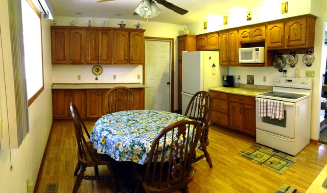 64 Eastfield Road Montgomery, IL 60538 - Photo 10 of 22 a kitchen with stainless steel appliances kitchen island granite countertop a table chairs and a refrigerator