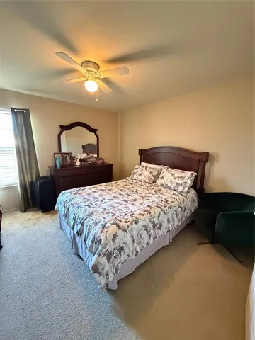a bedroom with a bed and dresser with mirror