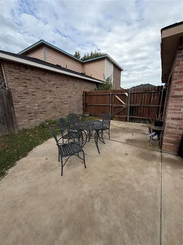 a backyard of a house with table and chairs