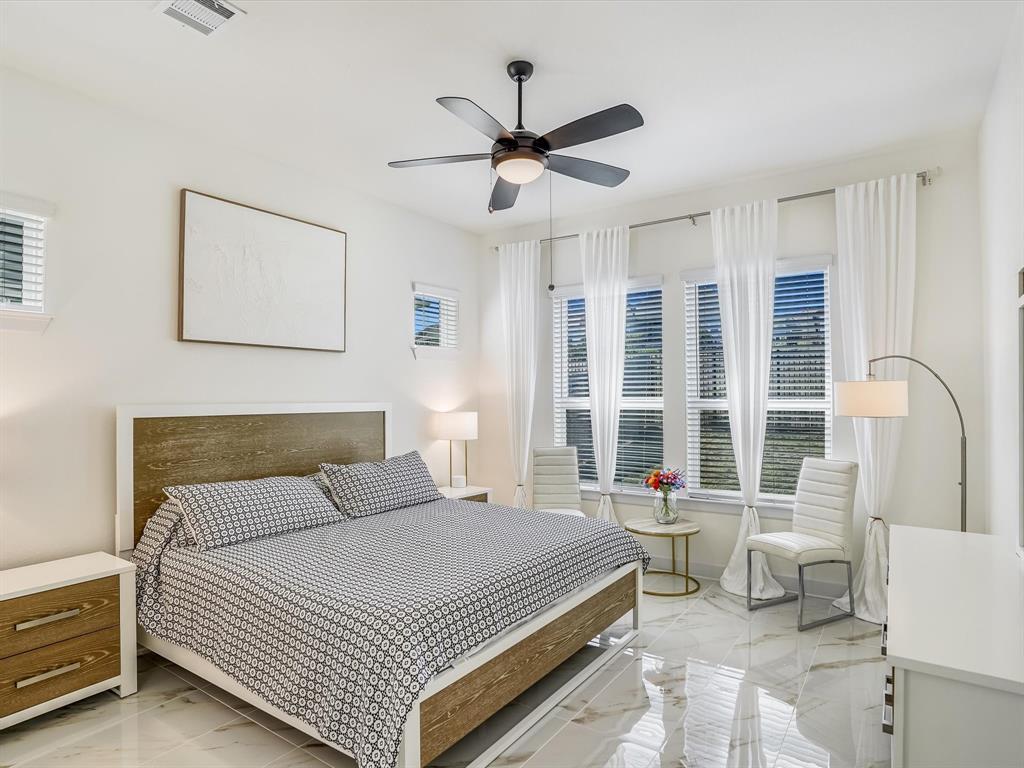 889 Hazy Hills Loop Dripping Springs, TX 78620 - Photo 13 of 20 Bedroom featuring light marble finish floors and a ceiling fan