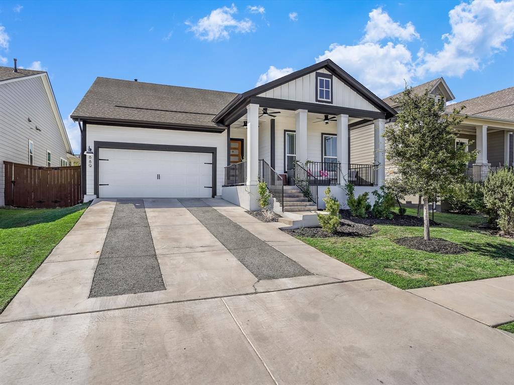 889 Hazy Hills Loop Dripping Springs, TX 78620 - Photo 2 of 20 View of front of home with a ceiling fan, driveway, a porch, an attached garage, and board and batten siding