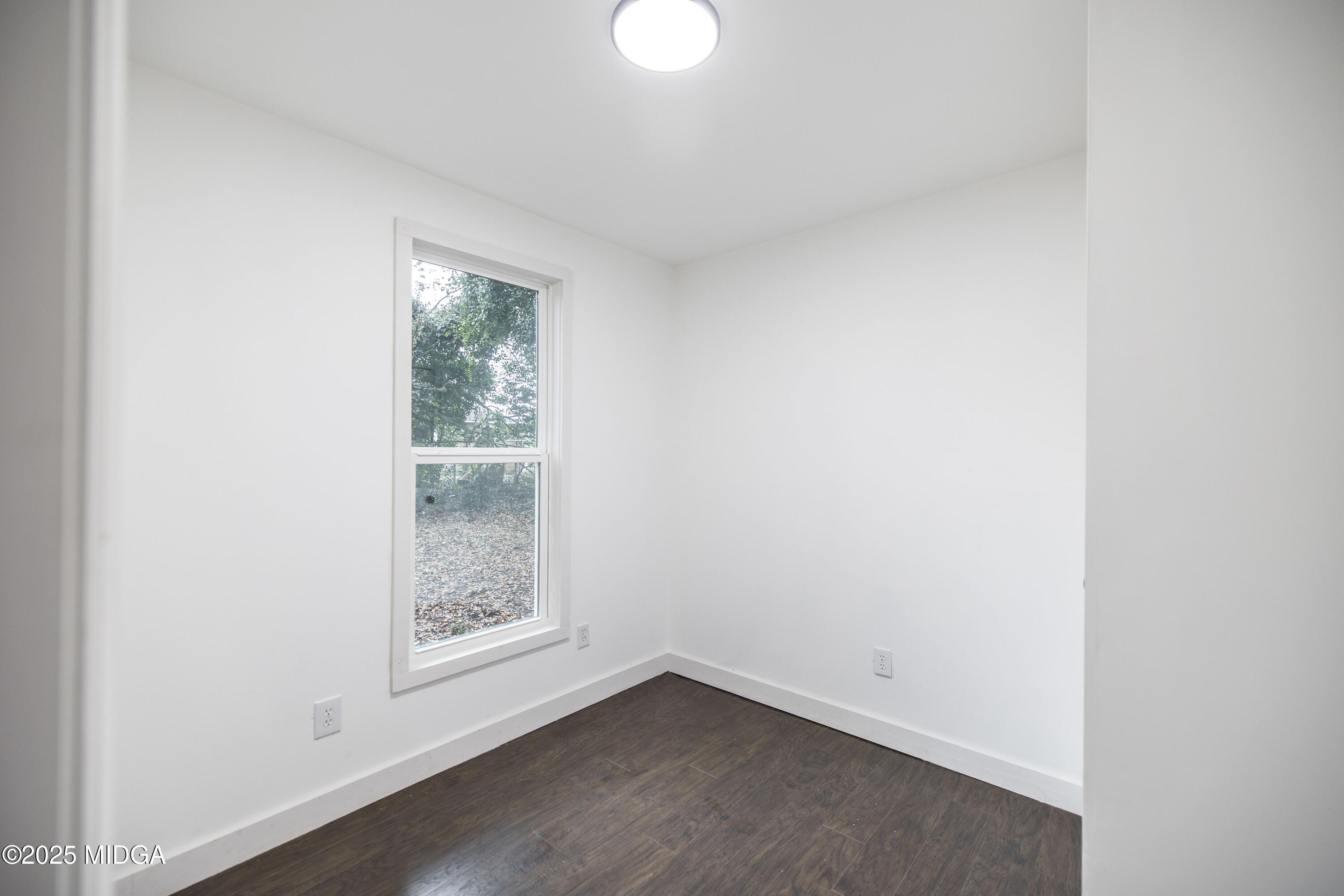 335 Lincoln Avenue Macon, GA 31201 - Photo 18 of 20 a view of an empty room with wooden floor and a window
