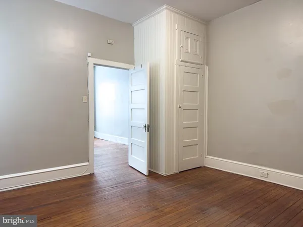a view of empty room with wooden floor