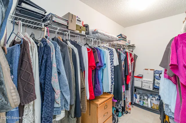 a view of walk in closet with clothes
