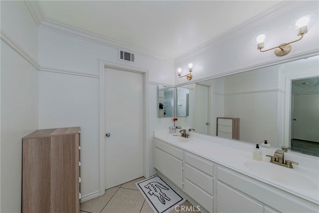 5010 Golondrina Way, Unit 64 Oceanside, CA 92057 - Photo 12 of 31 a bathroom with a double vanity sink a mirror and a shower
