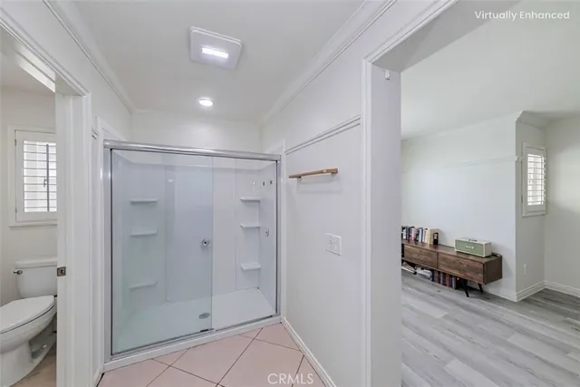 a view of a bathroom from a hallway and a livingroom with furniture