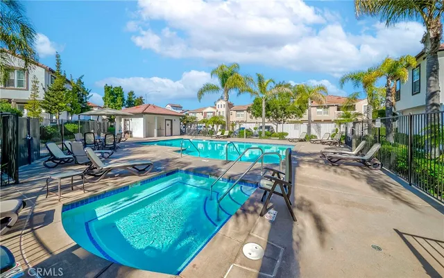 a view of a swimming pool with a patio and a yard