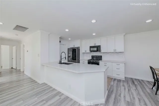 a kitchen with white cabinets and stainless steel appliances