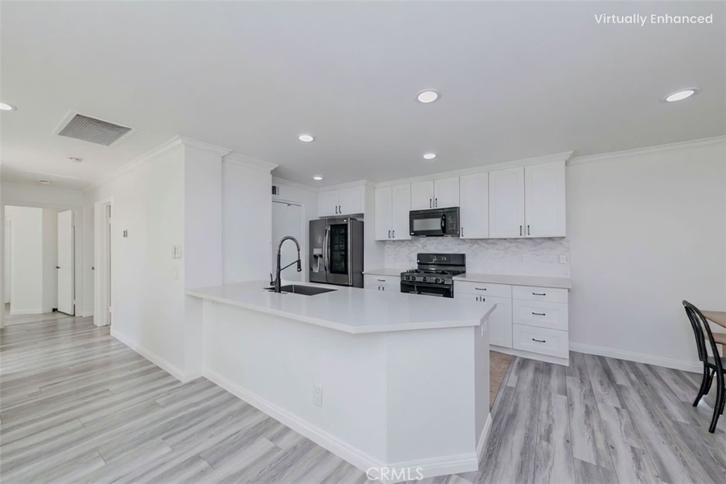 5010 Golondrina Way, Unit 64 Oceanside, CA 92057 - Photo 6 of 31 a kitchen with white cabinets and stainless steel appliances