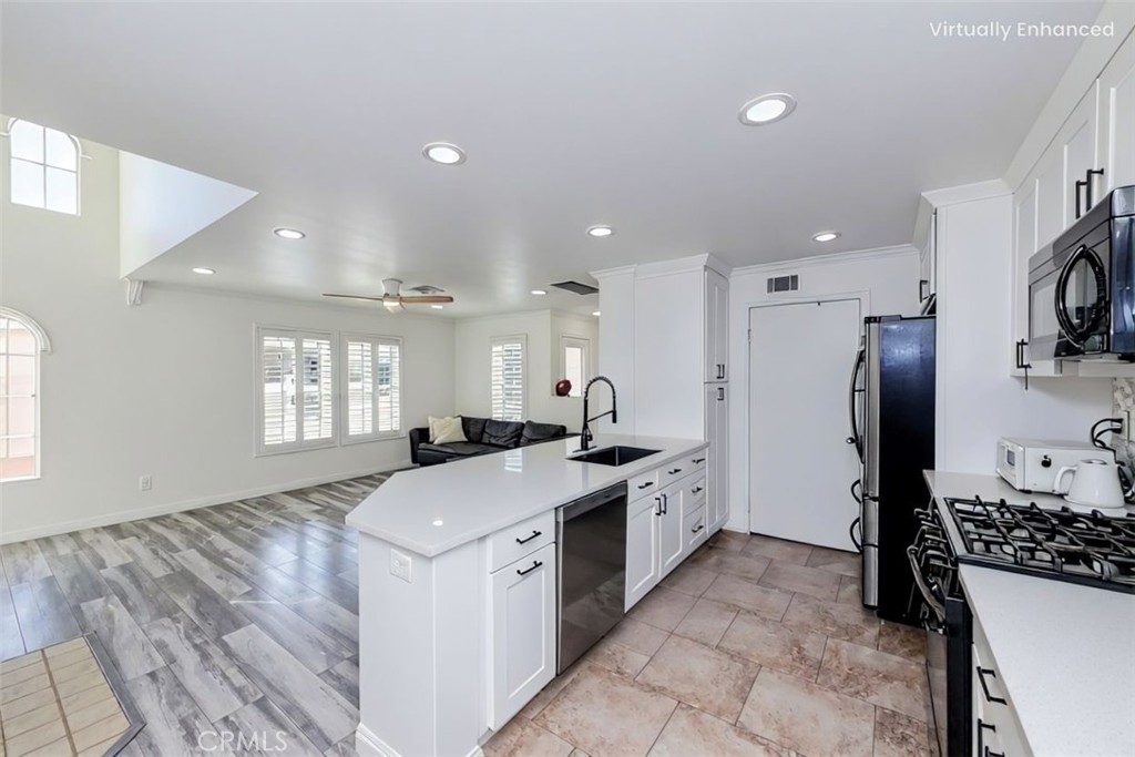 5010 Golondrina Way, Unit 64 Oceanside, CA 92057 - Photo 7 of 31 a kitchen with stainless steel appliances kitchen island a sink stove and refrigerator