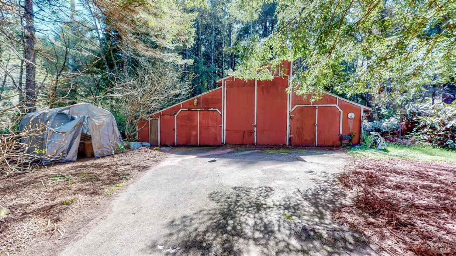 3535 Patricks Point Drive Trinidad, CA 95570 - Photo 54 of 61 a view of a barn in the backyard with large tree and wooden fence