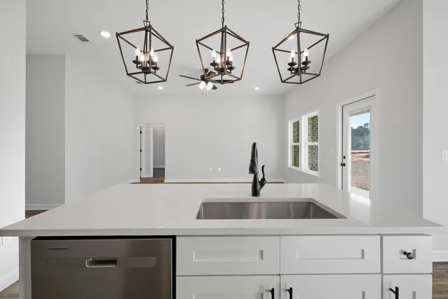 a kitchen with a sink and chandelier