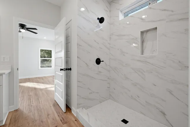 a view of an empty room with wooden floor and a window