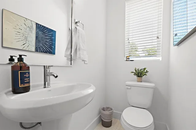a bathroom with a toilet a sink and mirror